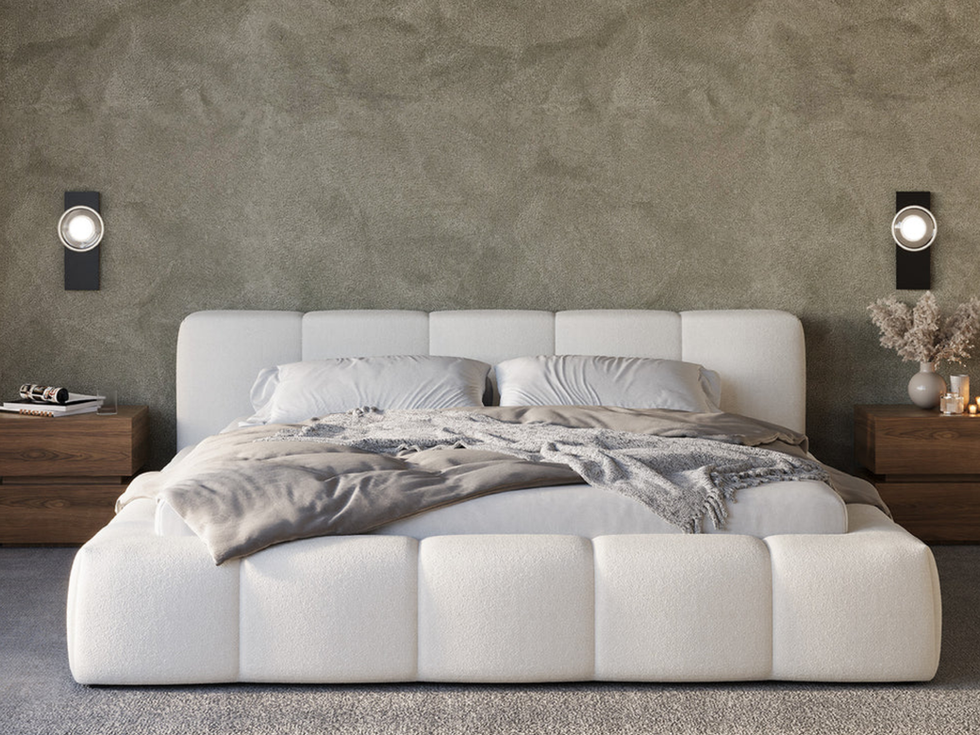 Modern white bed in a bedroom with decorative lights and decor.