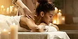 Woman receiving back massage in candlelit spa