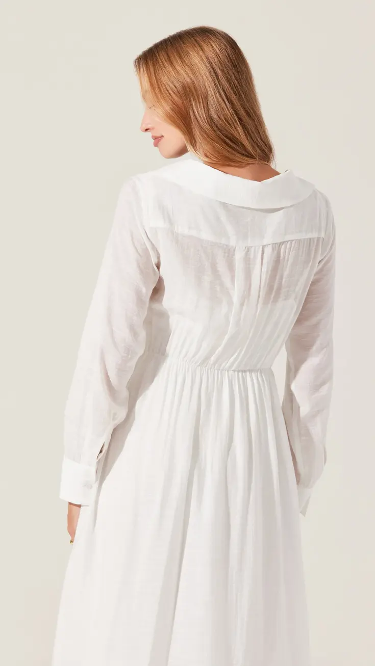 Woman wearing a white button-down long sleeve dress with a gathered waist
