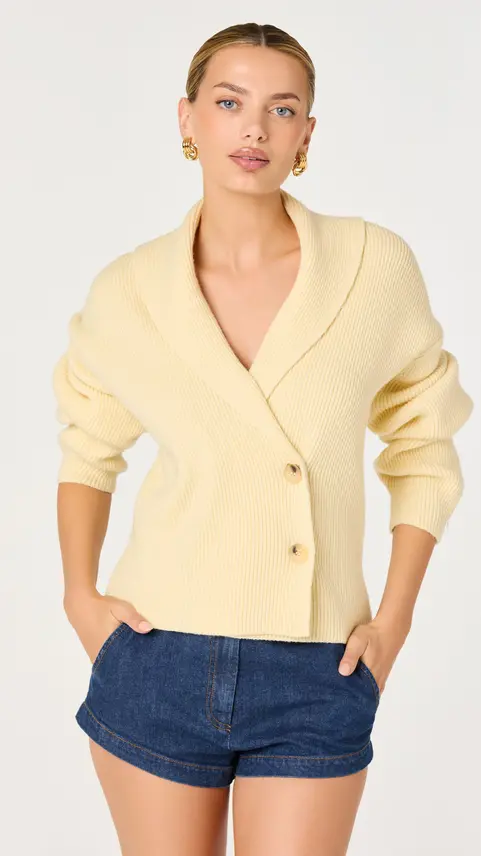 Model wearing a pale yellow collarless tailored blazer.