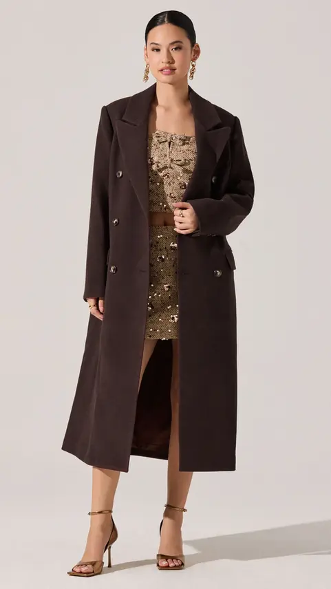 Long dark brown double-breasted coat over a printed dress