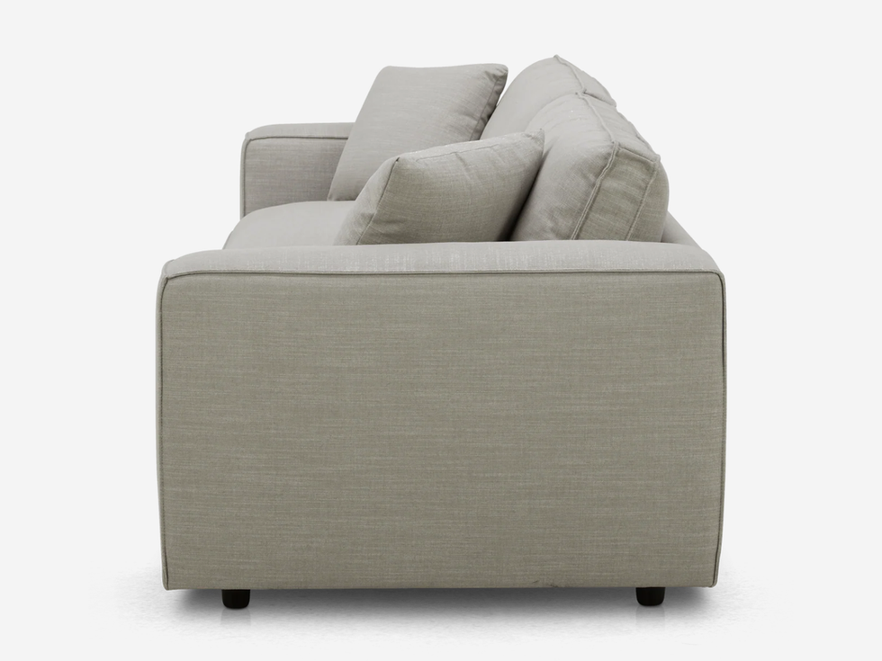 Side view of a beige sofa with multiple pillows