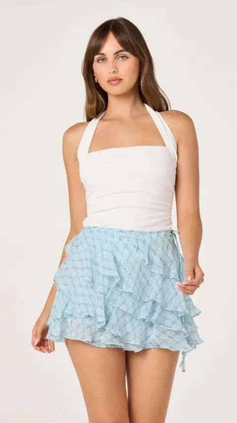 Woman in a white halter top and light blue ruffled skirt