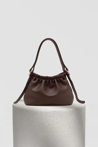 Brown leather handbag with a gathered top and gold hardware