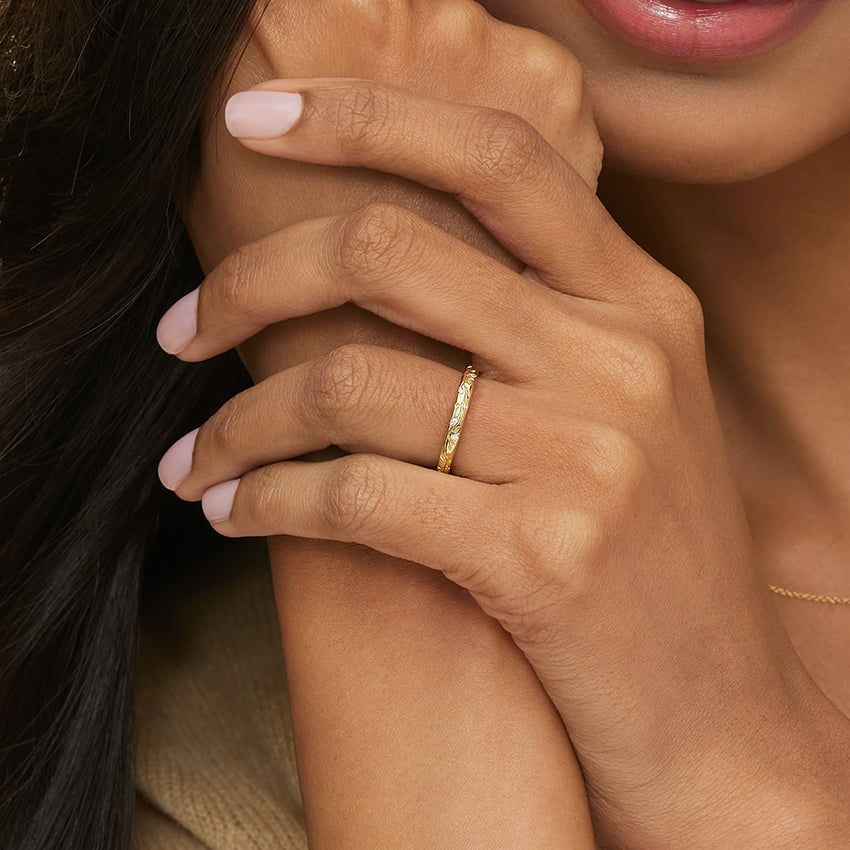 Woman's hand displays gold eternity band