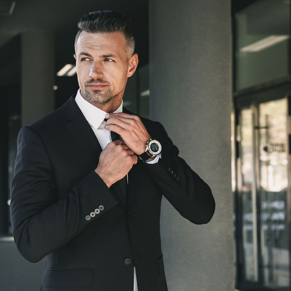 Man in suit adjusting tie