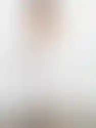 Woman wearing white strapless dress smiles, showing the design Charme.