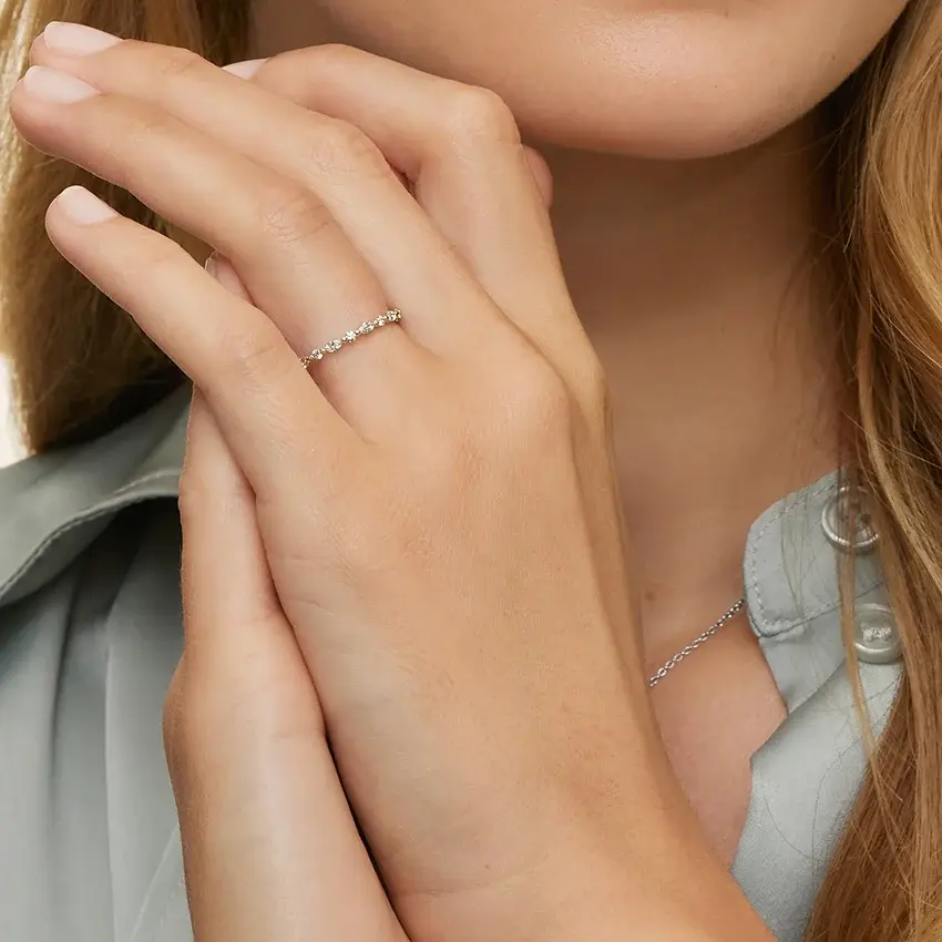 Woman's hand showcasing delicate diamond ring