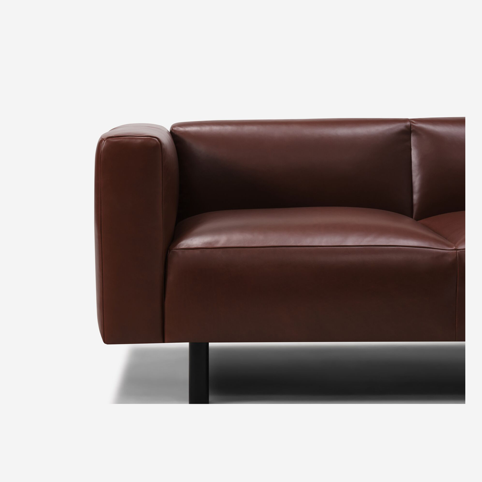 Brown leather sofa with black legs