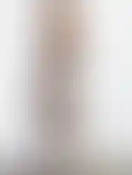 Woman wearing floral skirt and black top stands. Charme