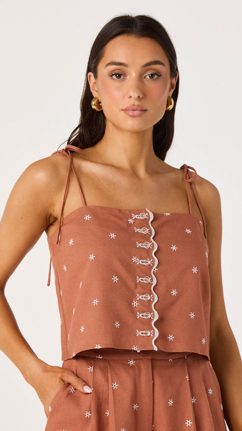 Woman wearing a rust-colored embroidered camisole top