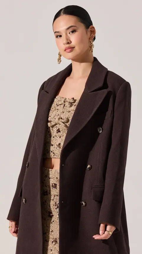 Woman wearing a collarless tailored blazer over a top