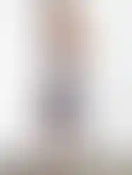 Woman wearing floral dress, posing, featuring high heels and Charme.