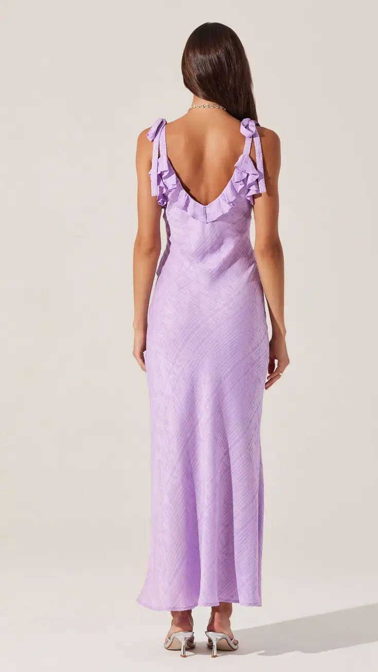 Woman in a lavender midi dress with a deep v-neck and tie straps, viewed from behind