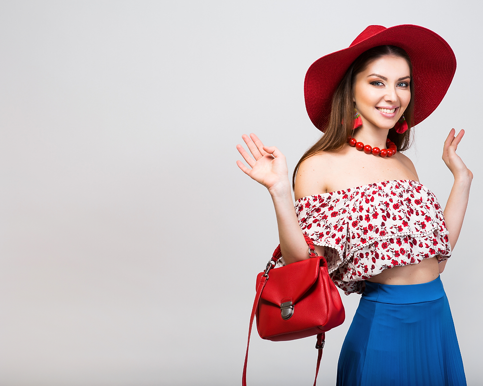 Smiling woman in red hat, floral top, blue skirt, and red handbag, waving