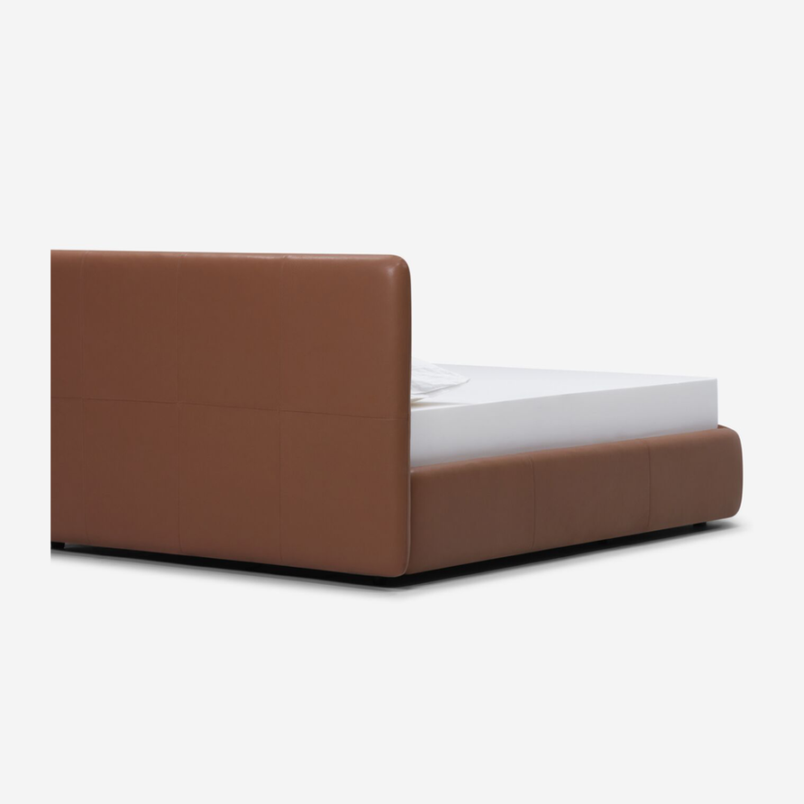 Brown leather bed frame with a white mattress