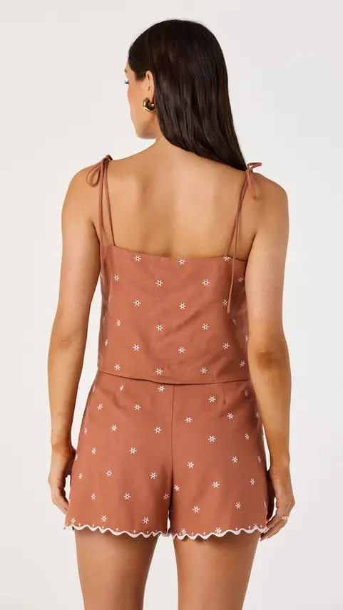 Back view of a woman wearing a terracotta polka dot top
