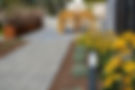 Walkway to home with pavers and flowers