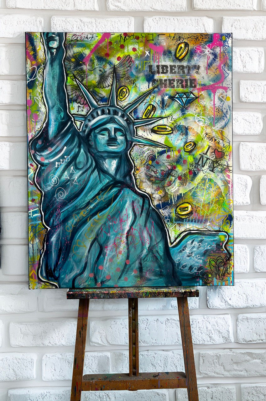 Painting of the Statue of Liberty with vibrant graffiti art and text on a white brick wall. Colors and symbols fill the background.