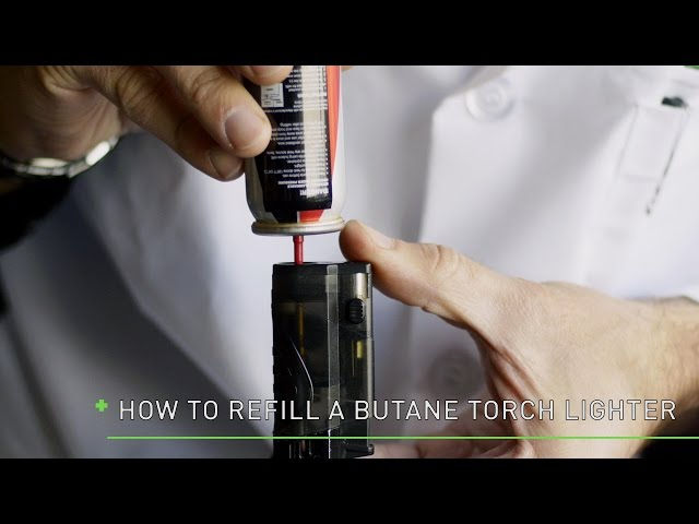 Close-up view of a butane canister being used to refill a lighter