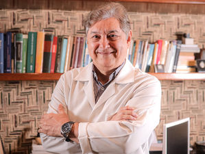 médico de jaleco e com os braços cruzados