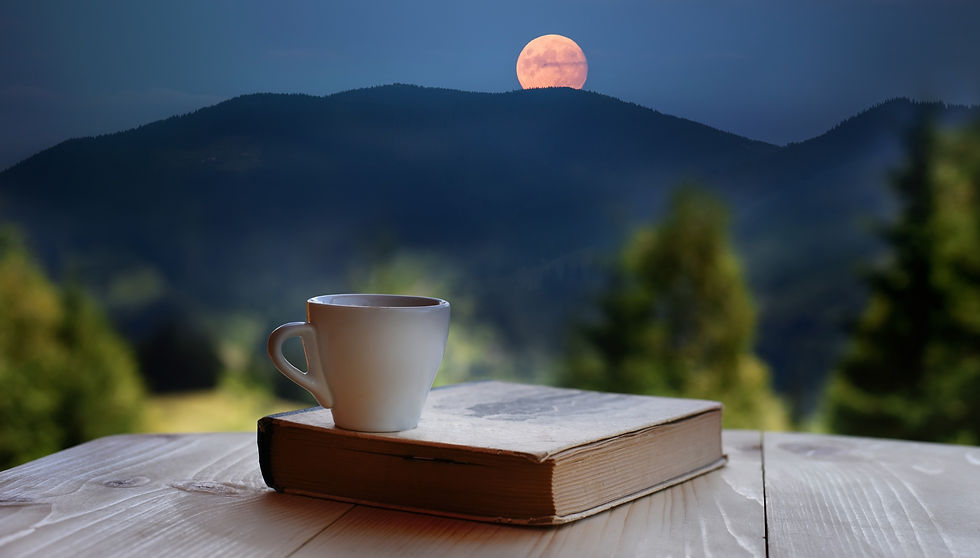 A coffee cup and a book against the backdrop of a mountain landscape with a full moon comi