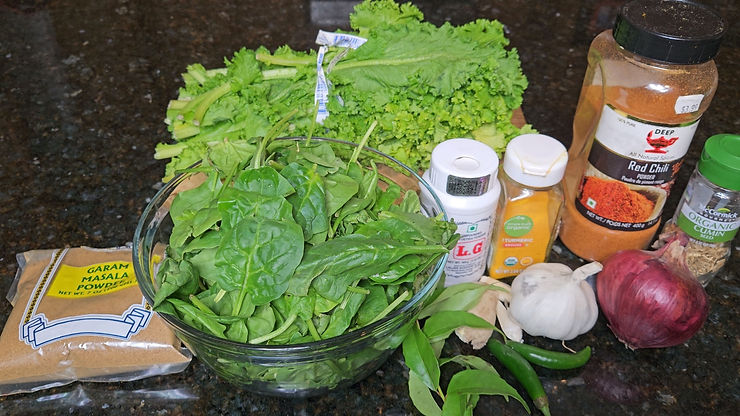 the ingredients to make saag lined up on a black countertop