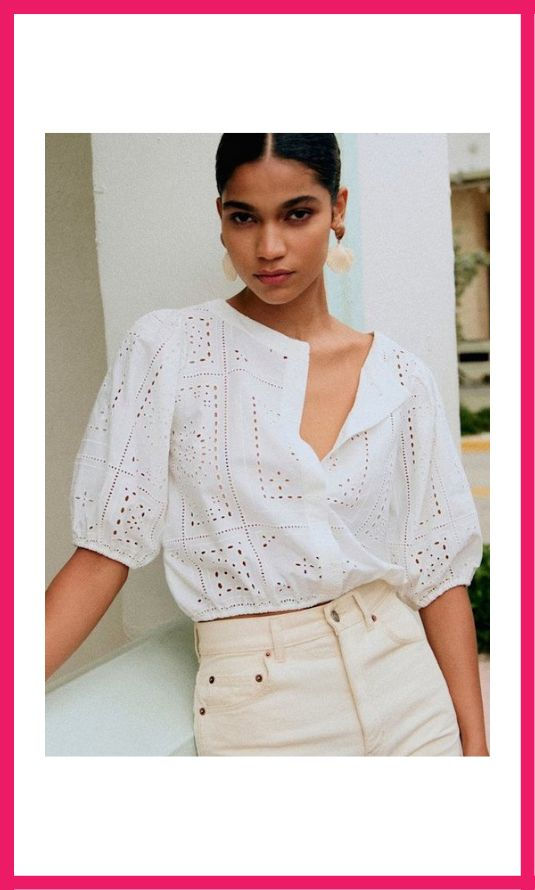 A woman wearing a white embroidered soft blouse, perfect for building a capsule wardrobe with