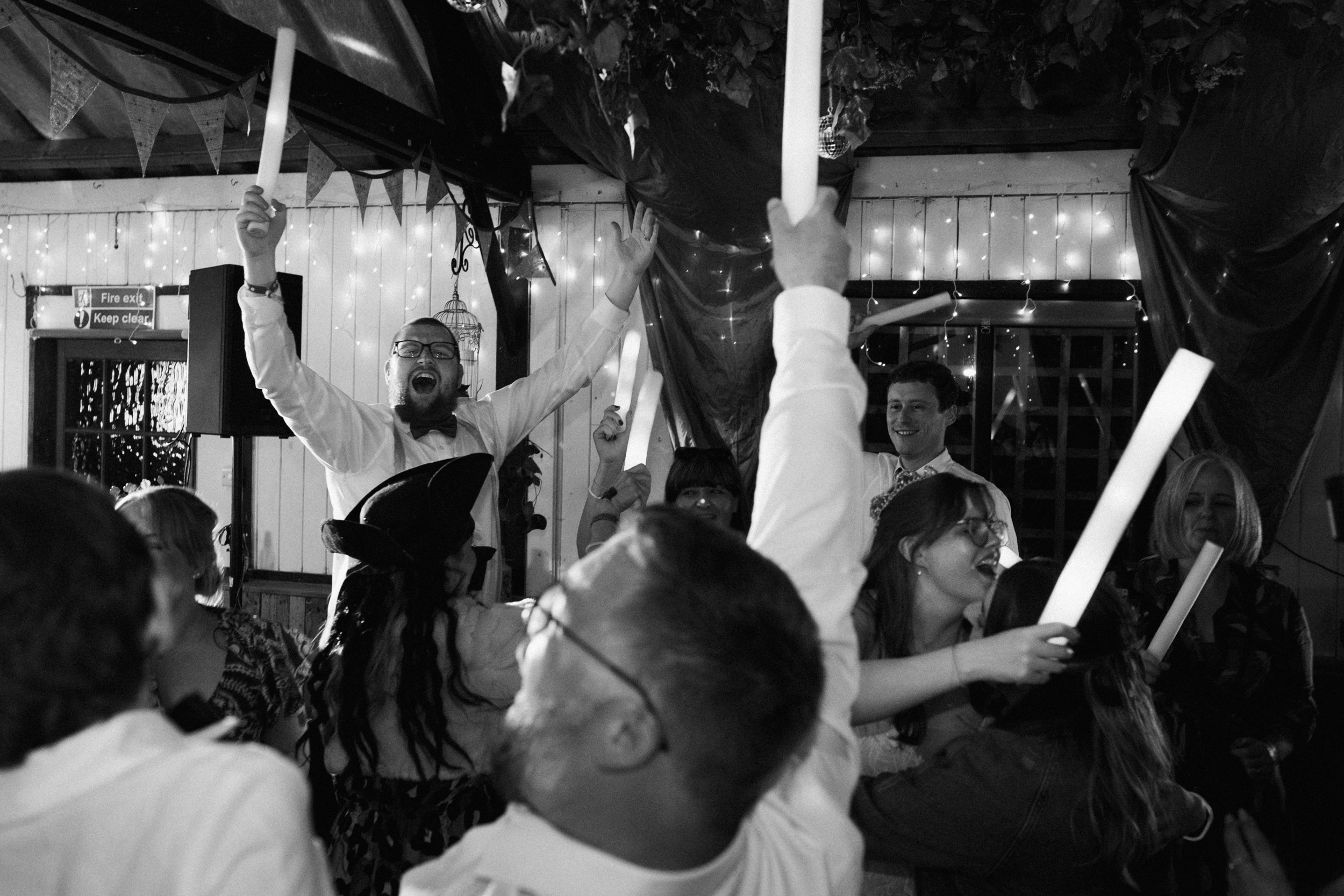 Documentary wedding reception photograph of guests dancing with glow sticks