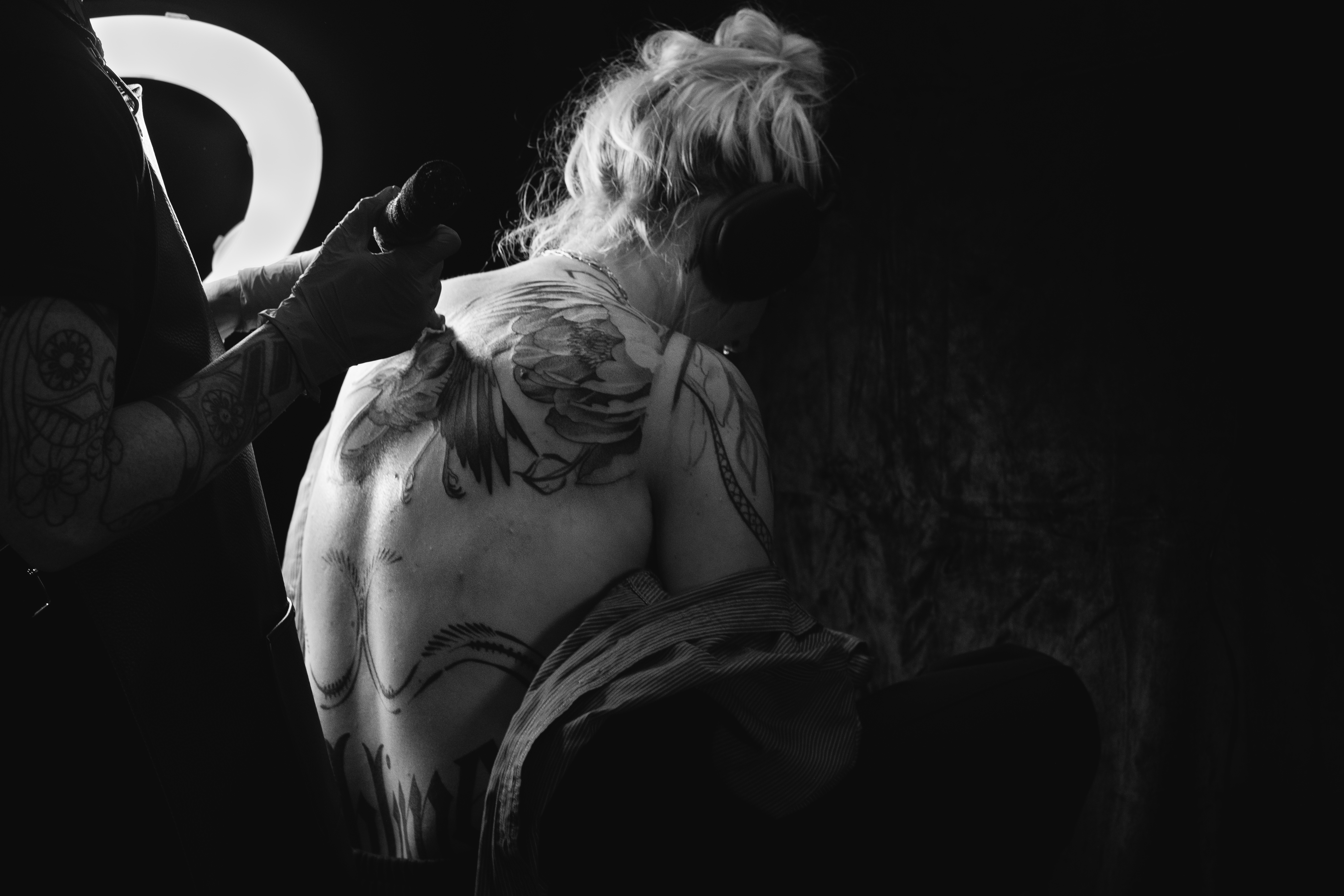 Tattoo photography from a convention showing artists at work, close-up details, and clients during sessions