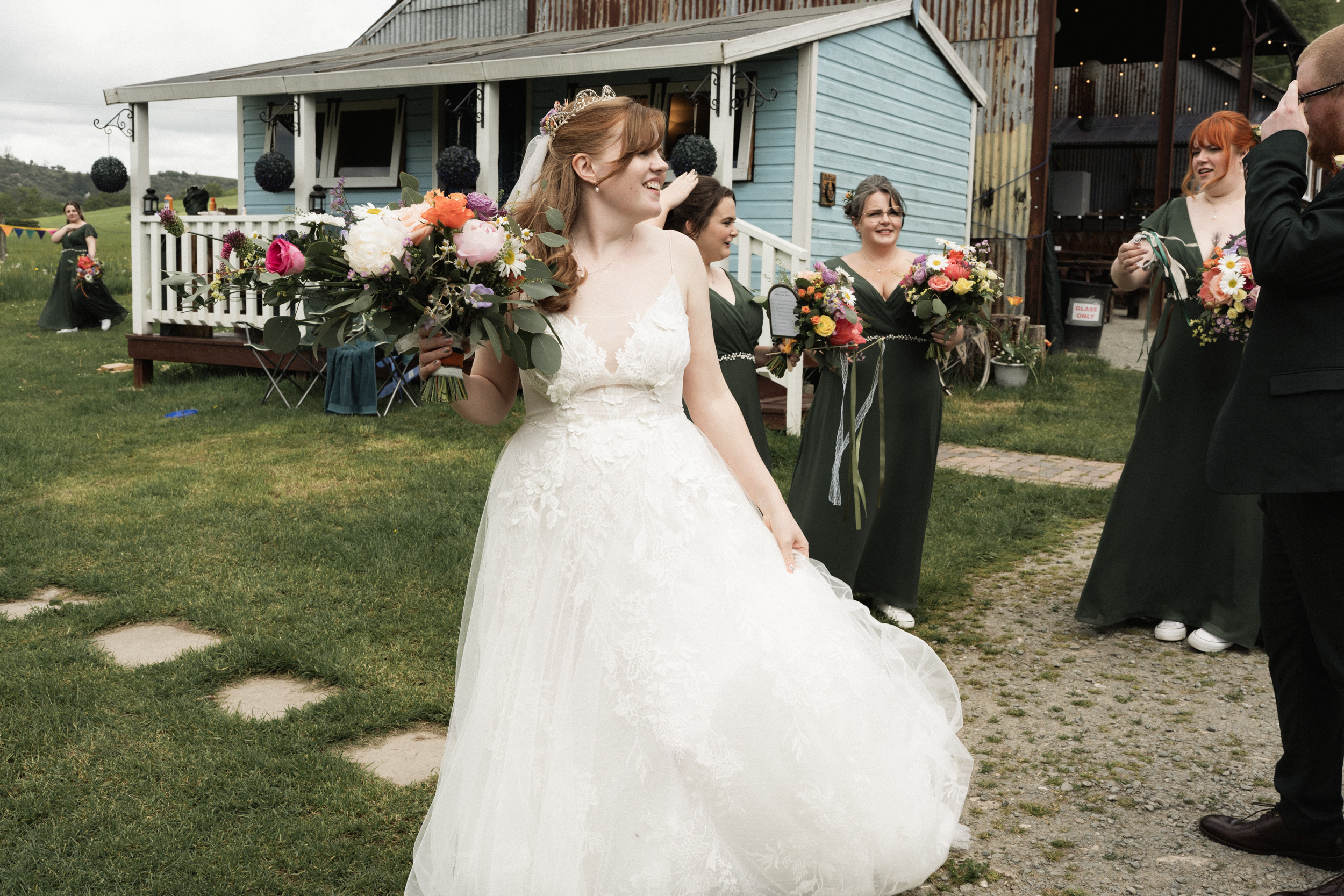 Unposed wedding photograph of bride surrounded by guests after the ceremony