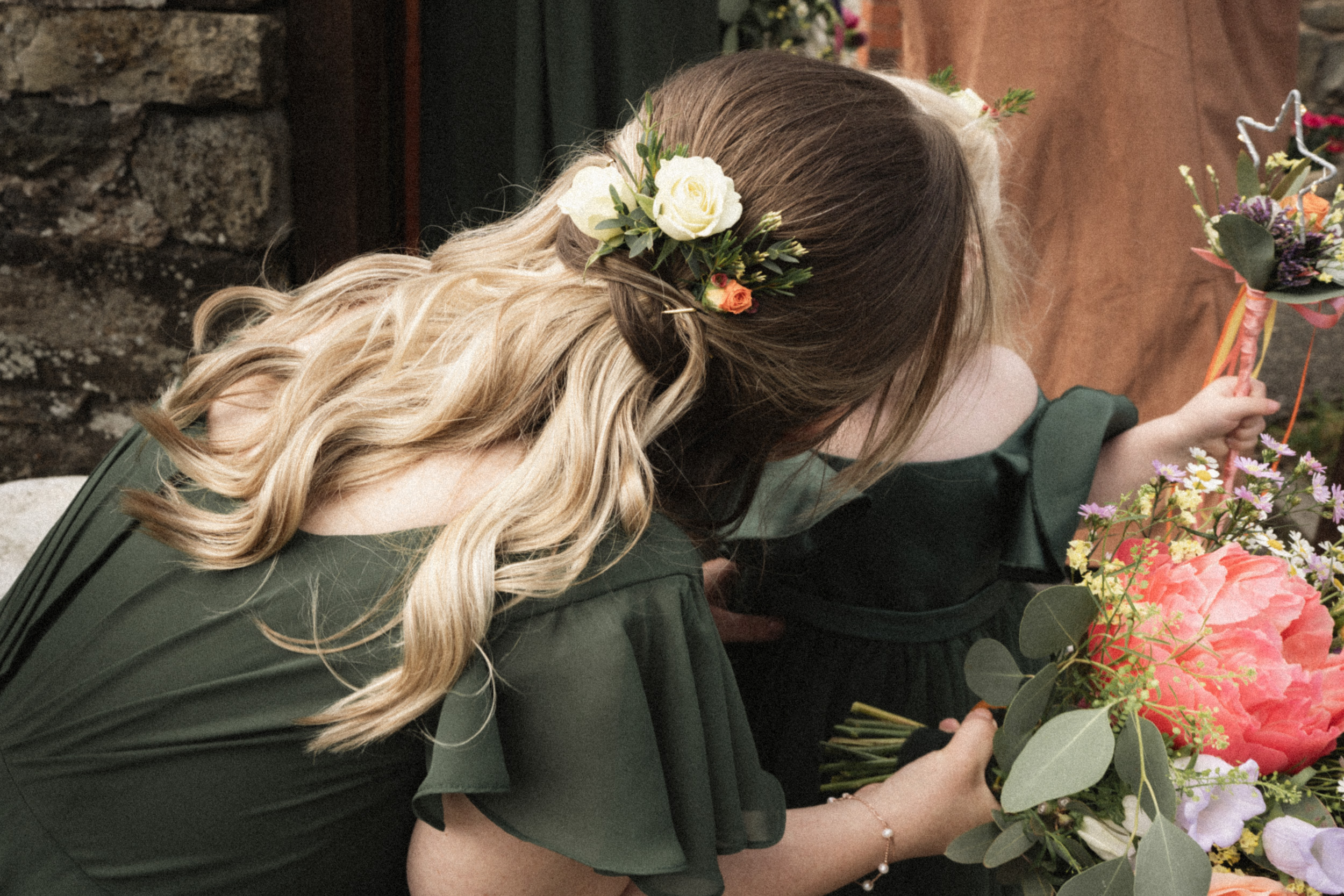 Unposed wedding photograph of a bridesmaid talking with a child before the ceremony