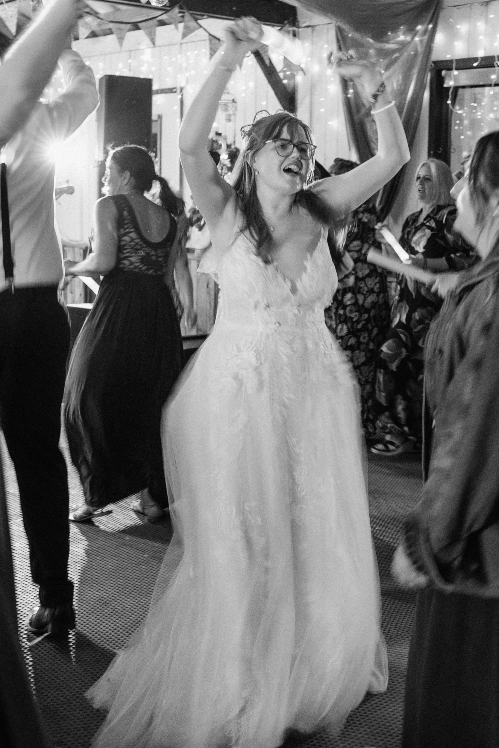 Black and white artistic photograph of the bride dancing.