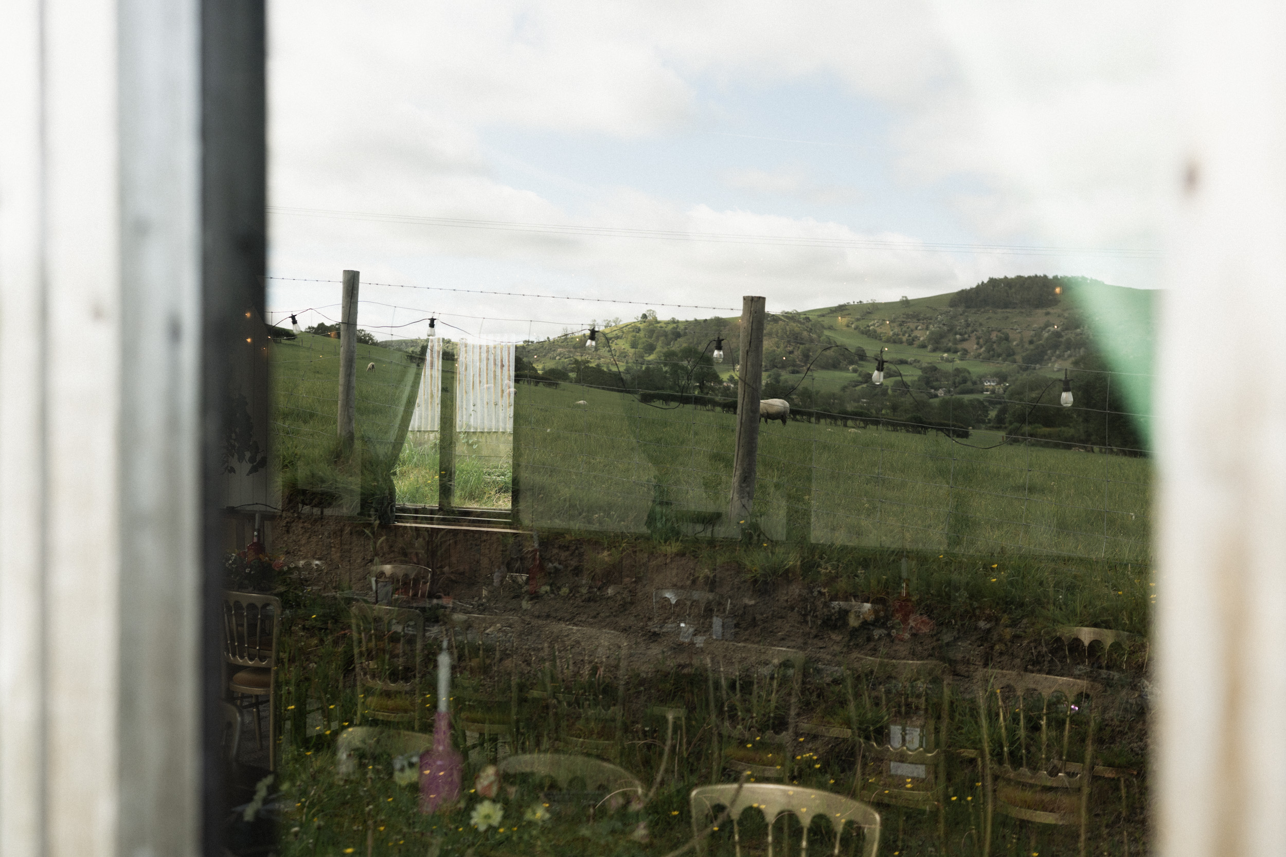 Atmospheric wedding venue detail with countryside reflected in a window