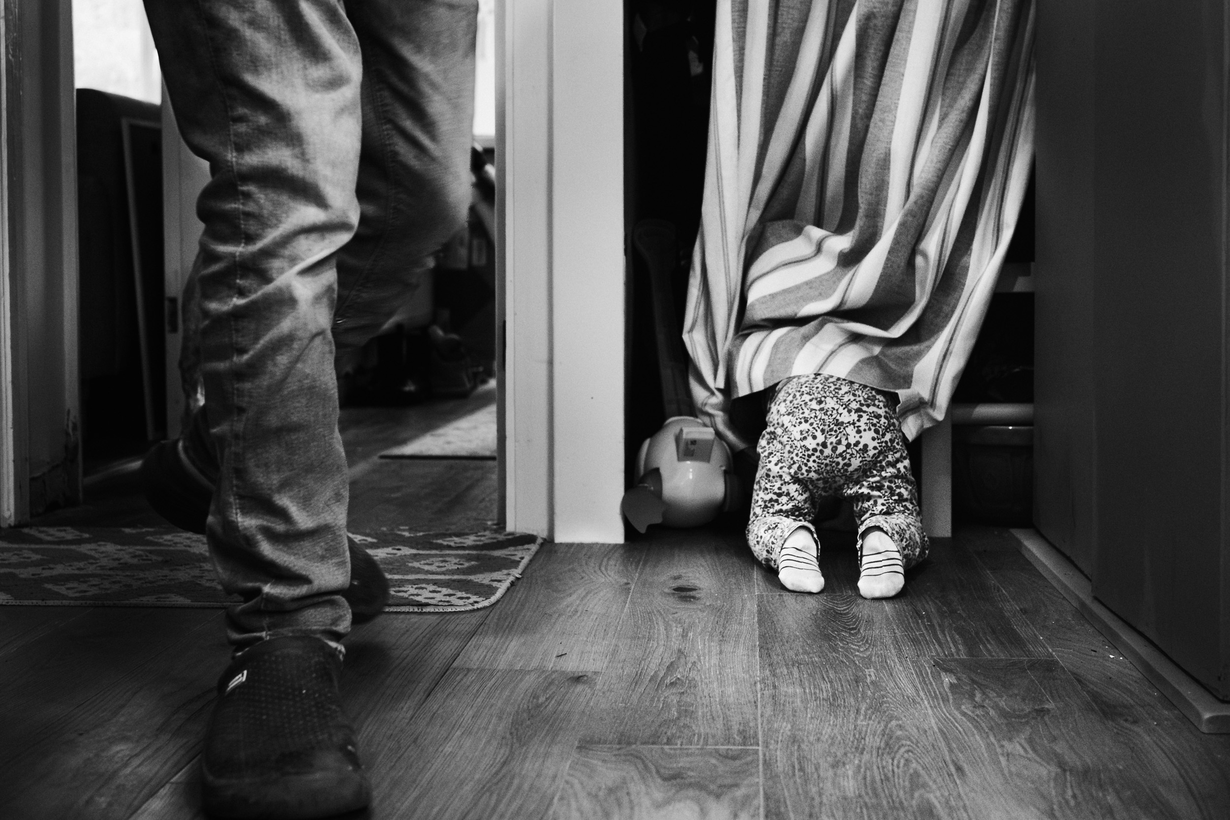 Unposed family photograph of a child hiding in a cupboard