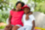 Close up portrait of two African kids sitting together on bench in park..jpg