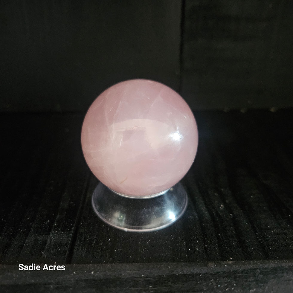 Polished pink gemstone Yopalite sphere on a clear stand.