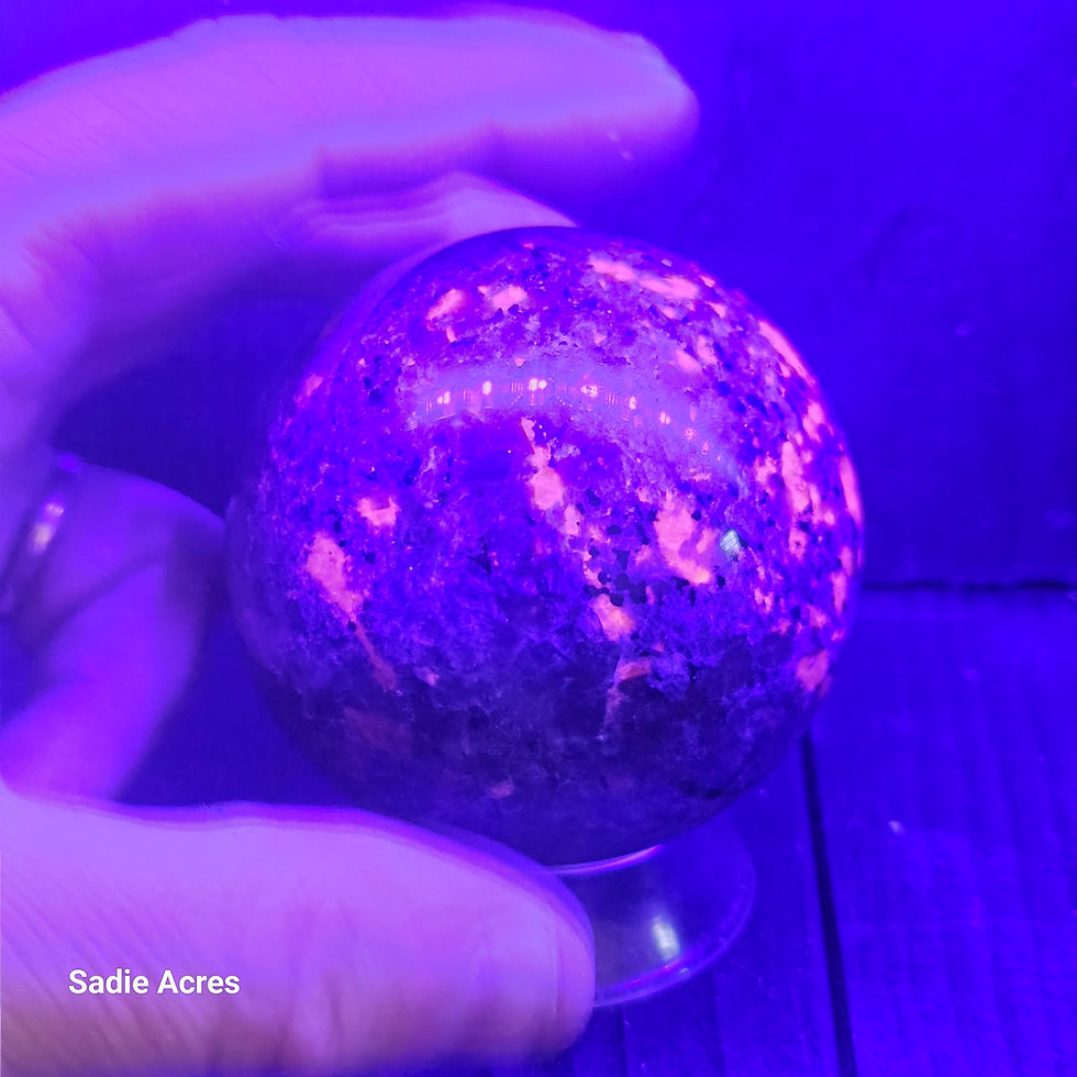Thumbnail: Hand-selected gemstone crystal sphere glowing under UV light.