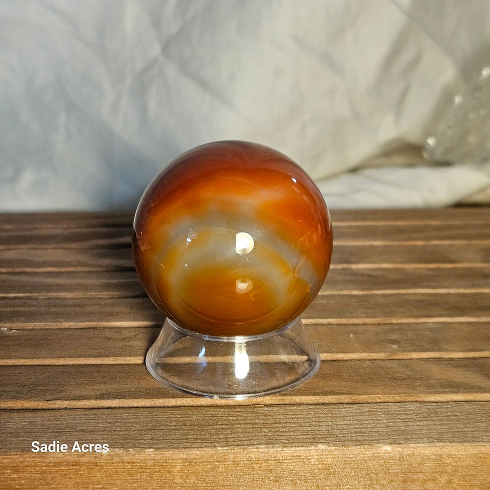 Hand-selected crystal carnelian sphere on a glass stand.