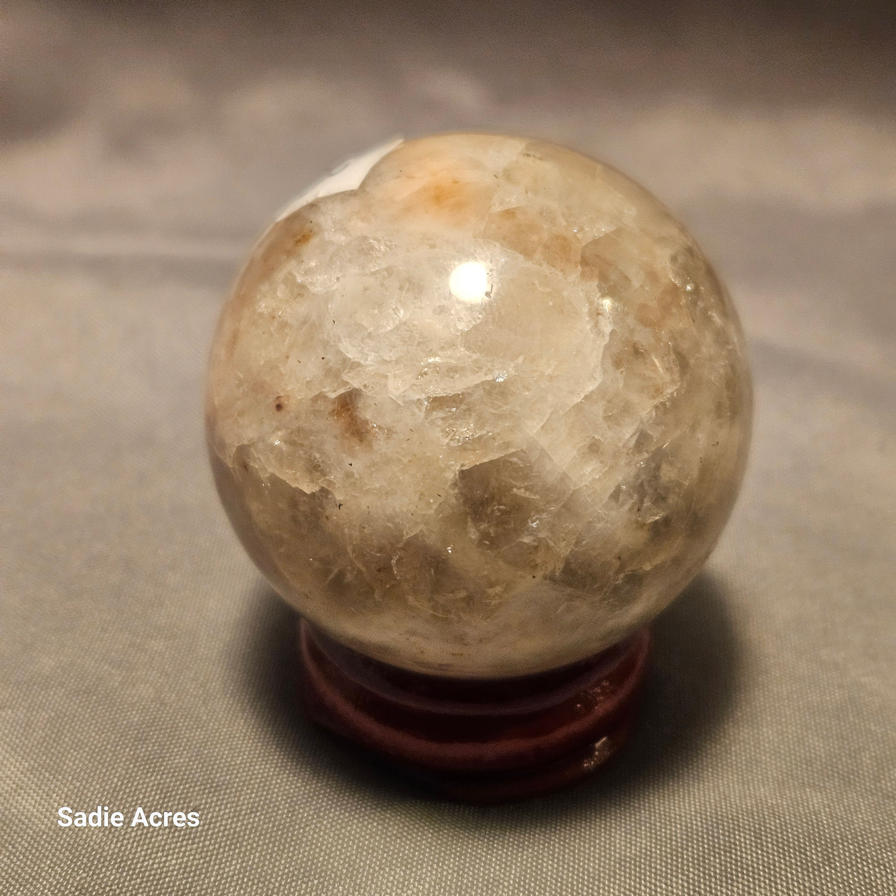 Hand-selected Yopalite crystal sphere on a wooden stand.