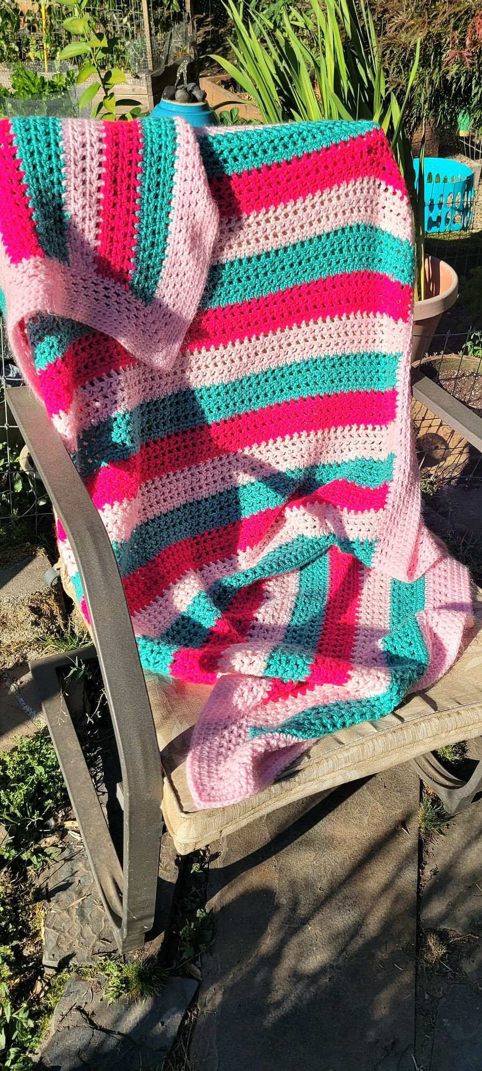 Handmade pink and teal striped crochet blanket