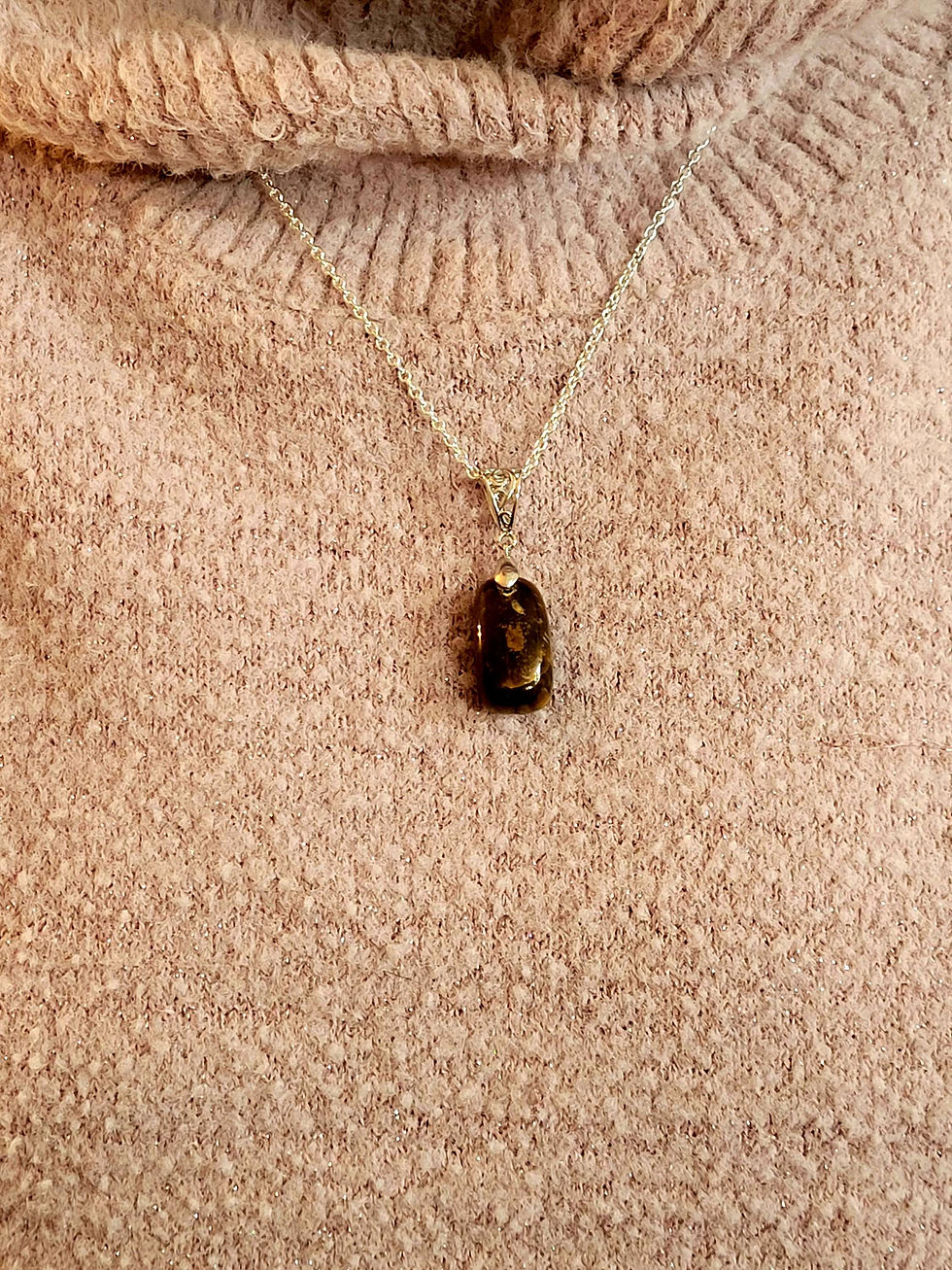 Thumbnail: Tiger Eye pendant on a chain against a sweater