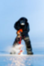 Angler using ice auger at Nash Outdoor Guide Service.