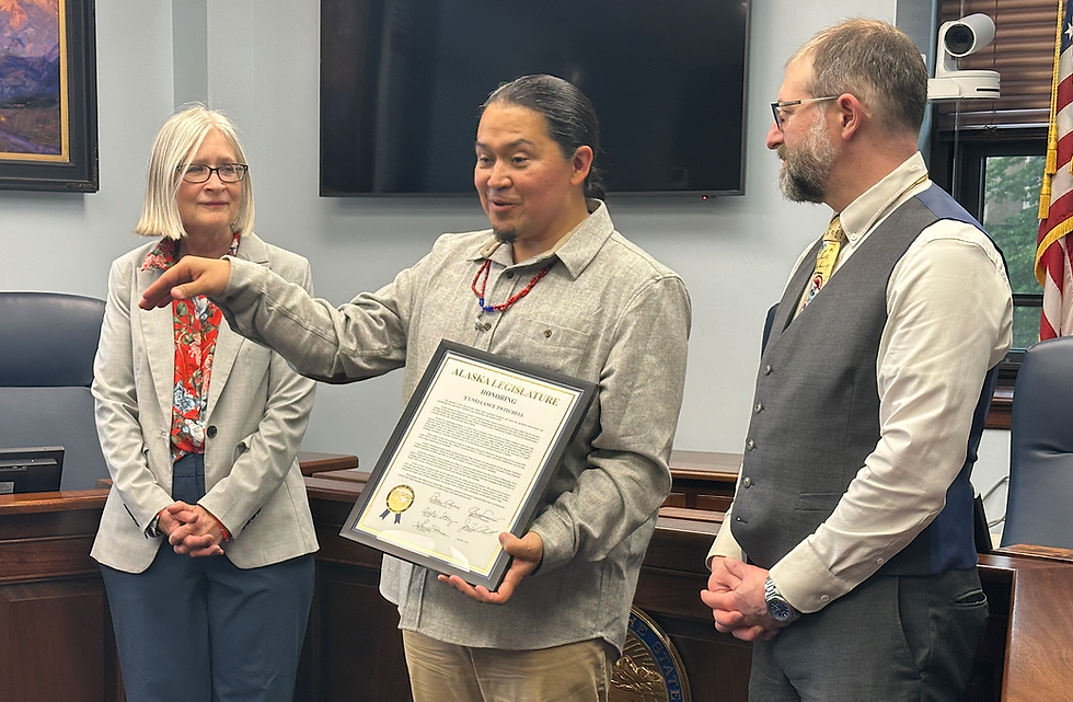 X̱’unei Lance Twitchell (center) receives a legislative citation from state Rep. Andi Story (D-Juneau) and state Sen. Jesse Kiehl (D-Juneau) at the Alaska State Capitol on Saturday, June 28, 2025. (Mark Sabbatini / Juneau Independent)