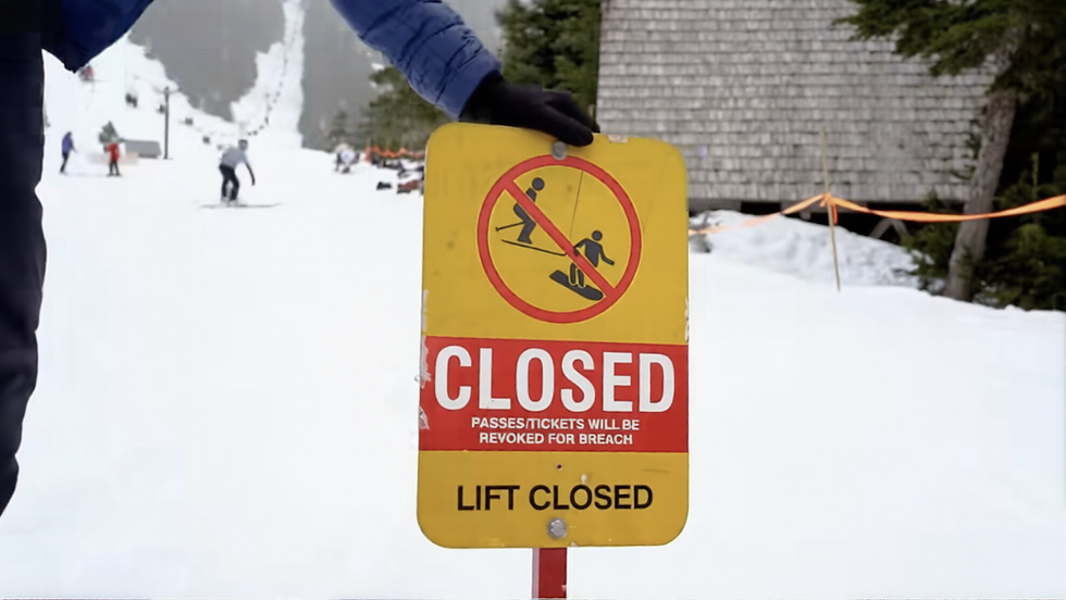 An Eaglecrest Ski Area employee sets out a closed sign for the chairlifts on Sunday, April 12, 2026, the final day of the resort’s 50th season. (Screenshot from Eaglecrest Ski Area video)
