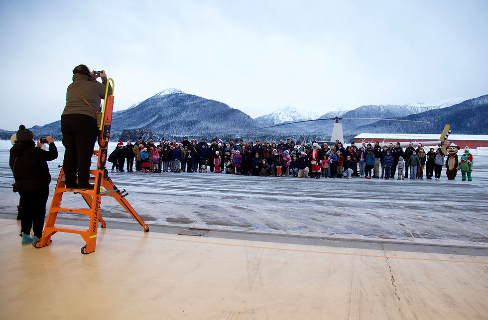 Participants in the annual Shop With A Cop pose for a group picture at the Alaska National Guard hangar on Saturday, Dec. 13, 2025. (Mark Sabbatini / Juneau Independent)