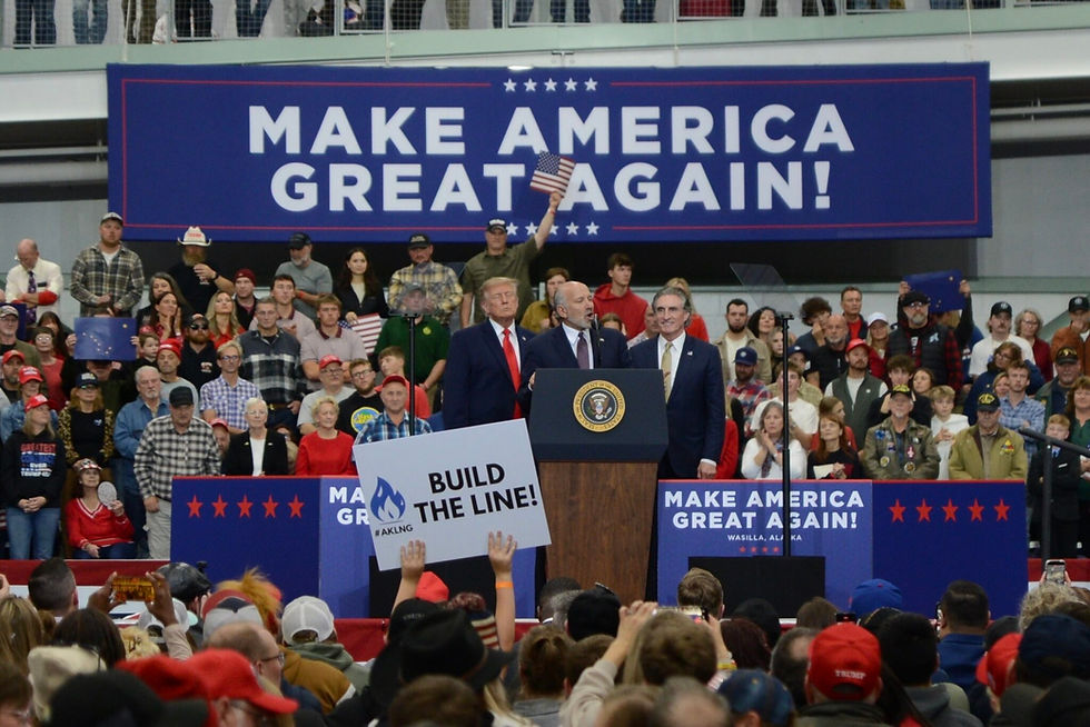 Commerce Secretary Howard Lutnick talks about the proposed trans-Alaska natural gas pipeline in front of President Donald Trump, left, and Interior Secretary Doug Burgum on Tuesday, Oct. 13, 2026, in Wasilla. In the foreground, a rally attendee holds up a sign urging construction of the pipeline. (James Brooks/Alaska Beacon)