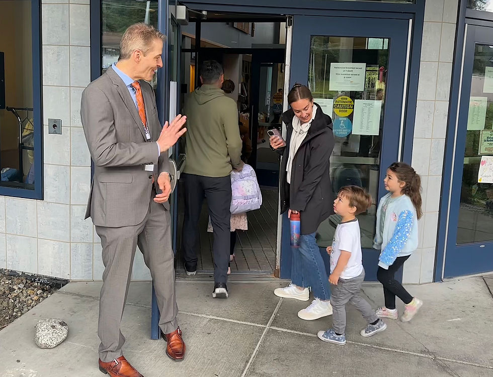 Juneau School District Superintendent Frank Hauser greets Jessica Lujan and two of her kids, Lucas, 3, and Olivia, 5, as they accompany sibling Emma, 7, to her first day as a second-grade student at Harborview Elementary School on Friday, Aug. 15, 2025. (Mark Sabbatini / Juneau Independent)