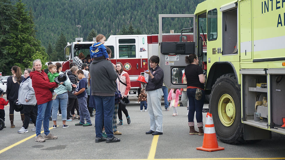 Capital City Fire/Rescue staff hand out plastic fire helmets at Trucks N' Stuff at Dimond Park on Saturday, July 12, 2025. (Ellie Ruel / Juneau Independent)