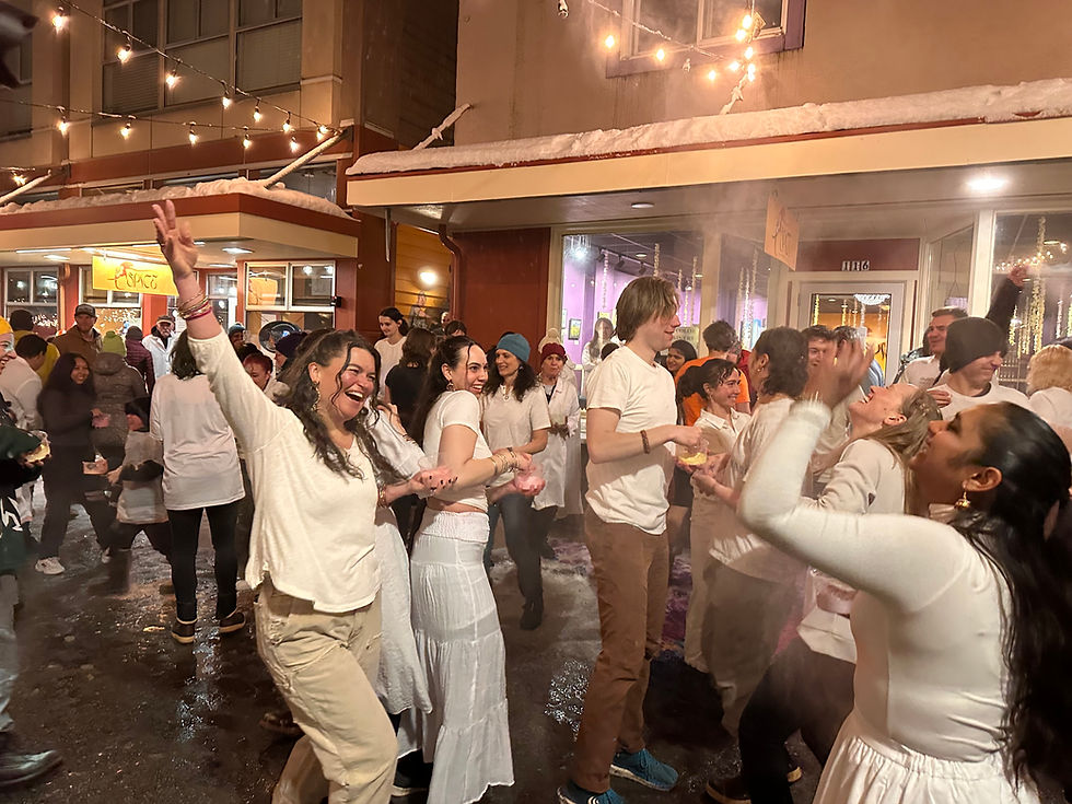 People throw colorful powder into the air in downtown Juneau during a Holi festival celebration on Monday, March 23, 2026. (Mark Sabbatini / Juneau Independent)